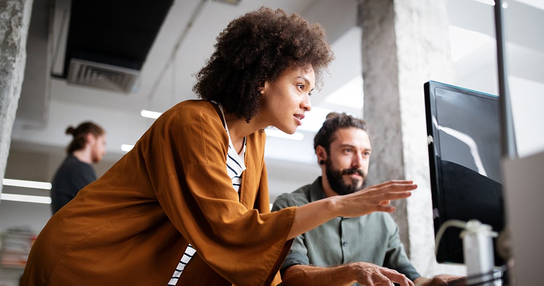 Two people meeting at a computer in an office