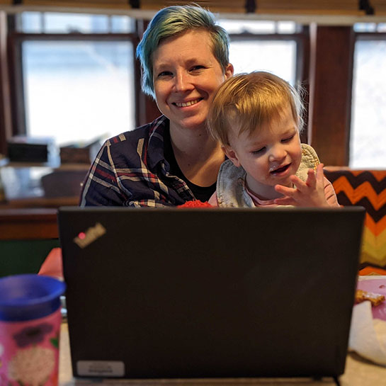Woman working from home with toddler on her lap