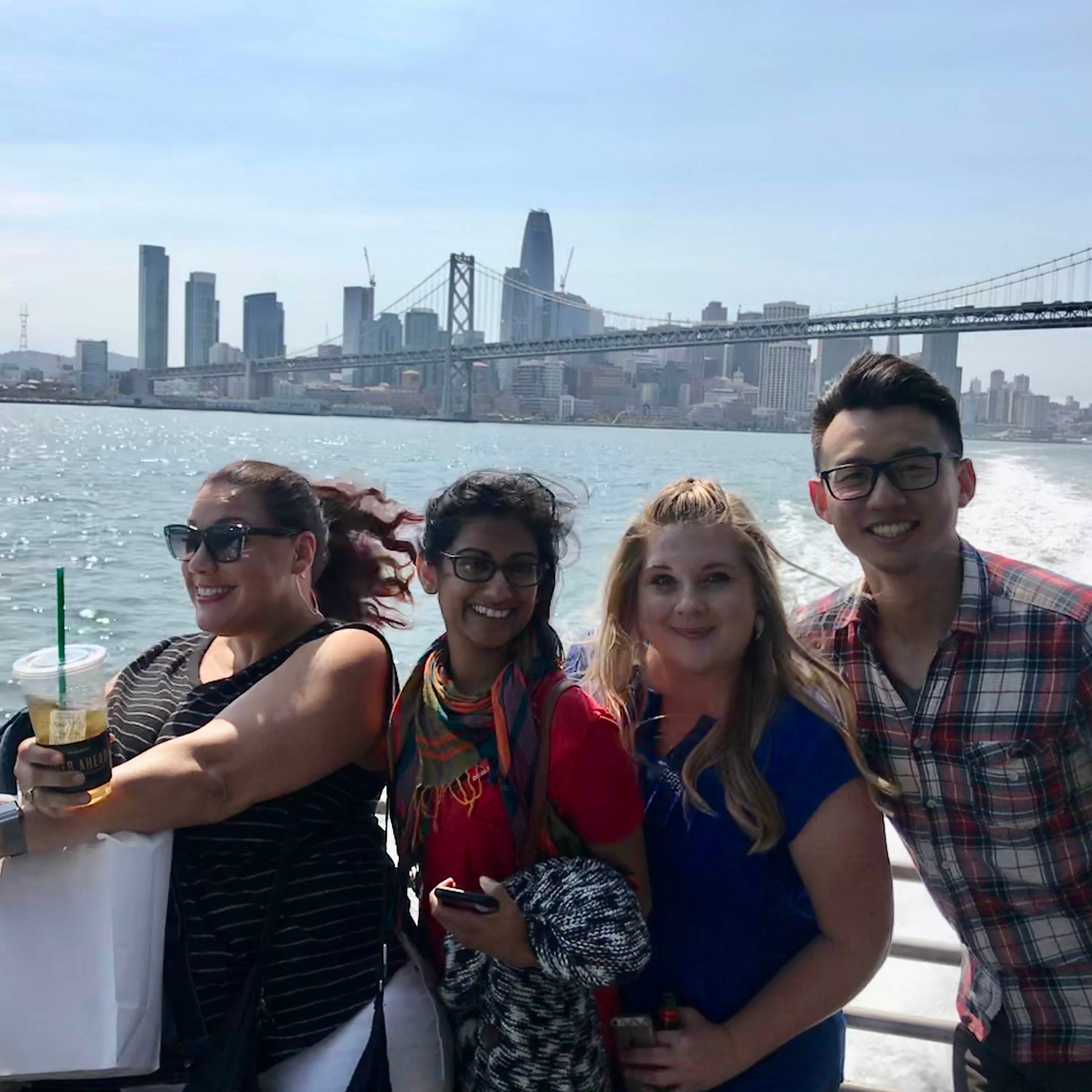 Group of four AnswerLabbers on a boat with San Francisco Skyline in the background