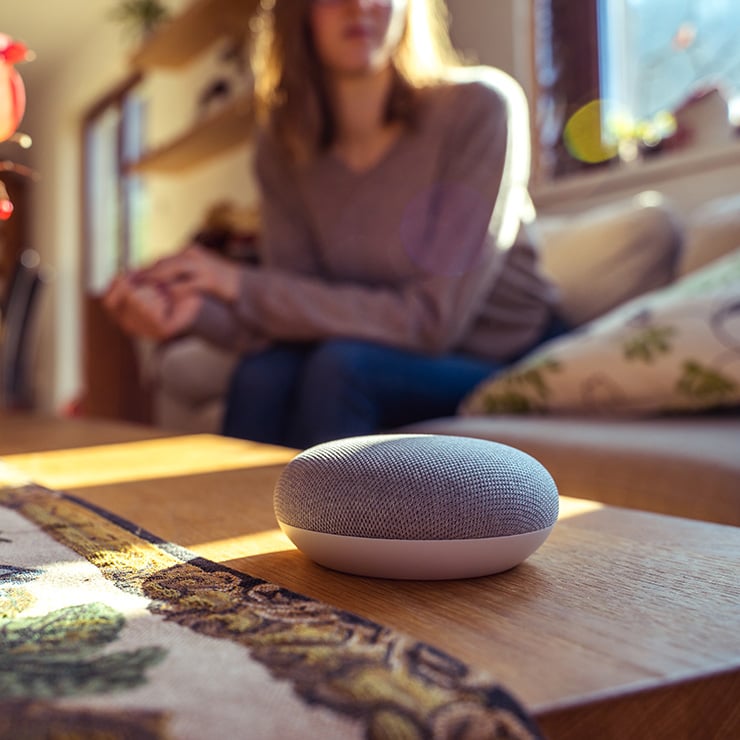 Smart speaker sitting on a coffee table in a woman's home