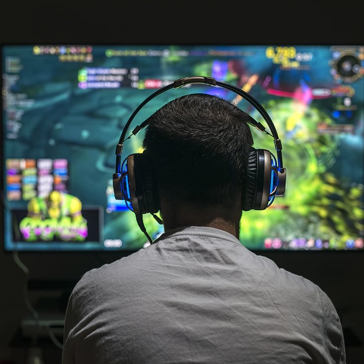 Man gaming on headset in front of video game screen