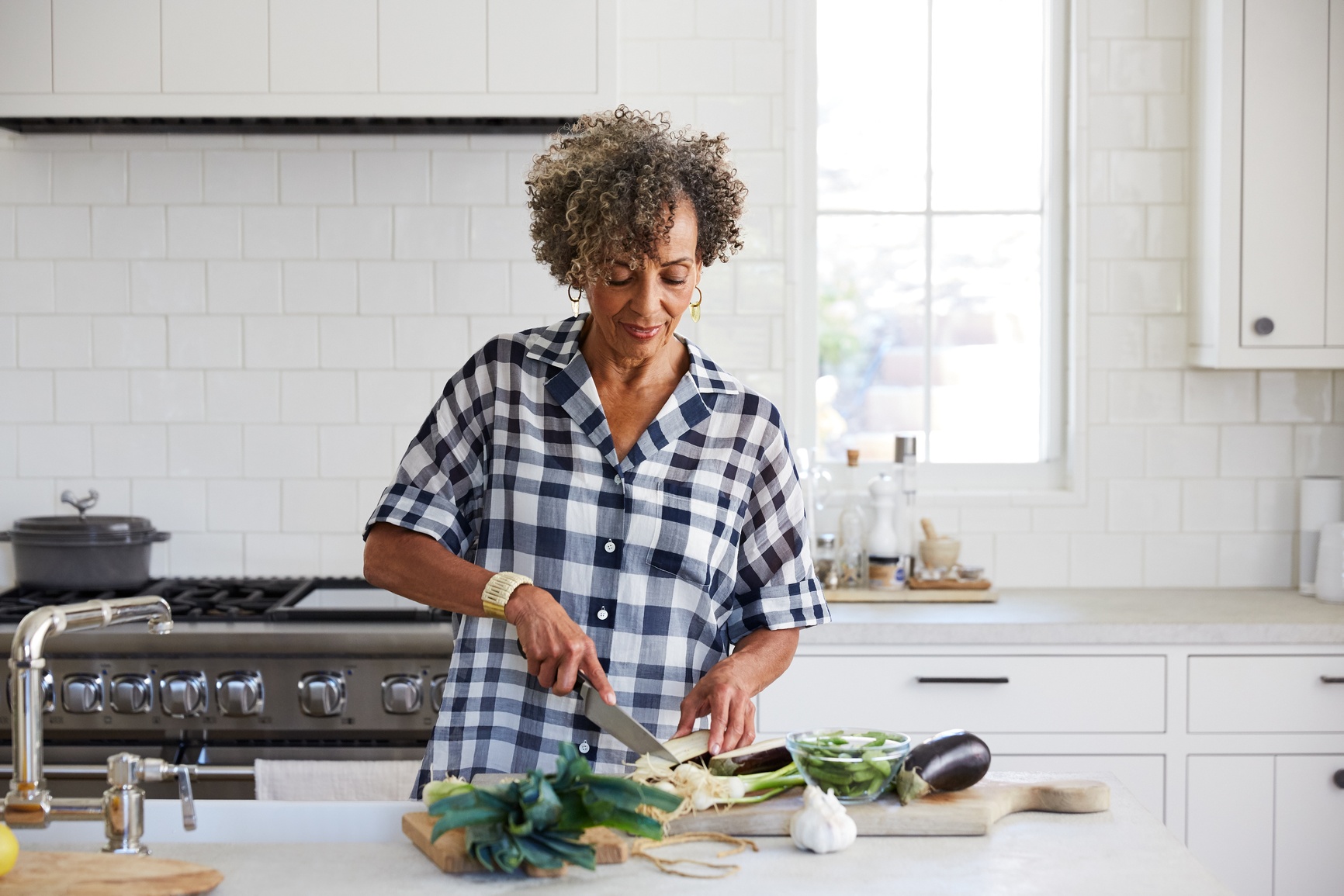 Woman in kitchen chopping vegetables