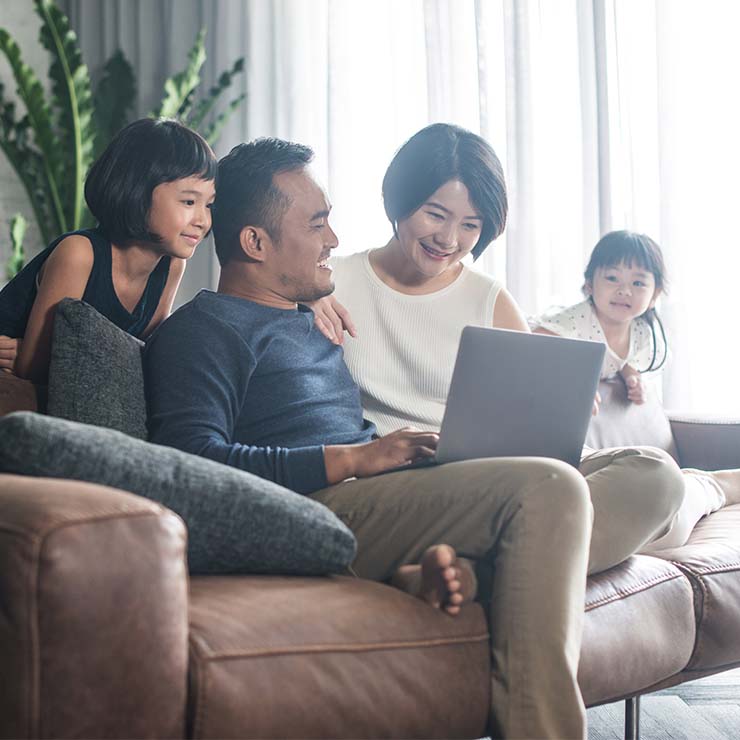 Two adults and two children at home on a couch