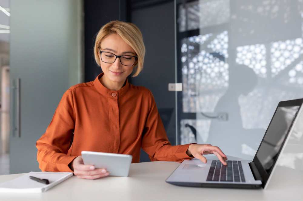 Businesswoman using tablet and laptop at desk