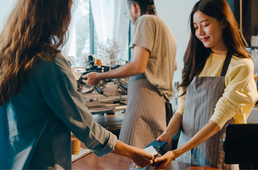 Woman paying for coffee using digital pay