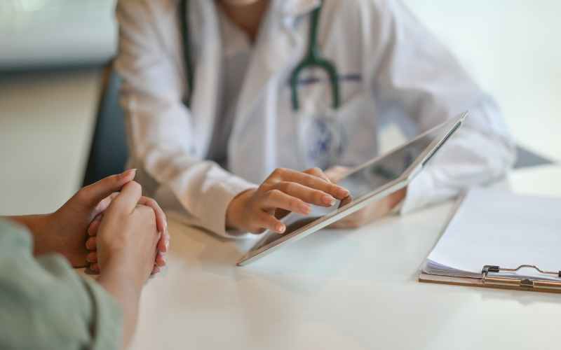 Doctor helping patient with tablet