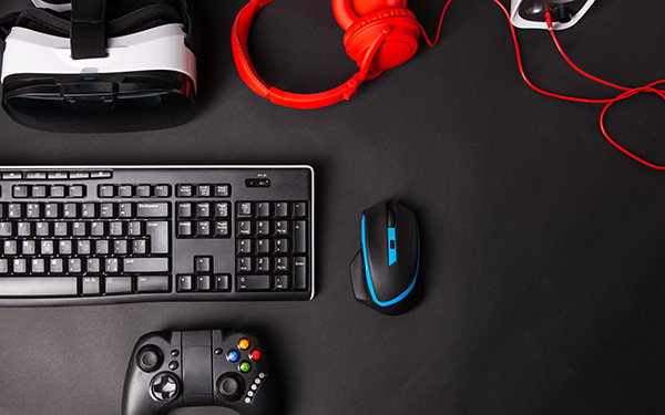 an overhead view of a keyboard, mouse, game controller, and headset on a table