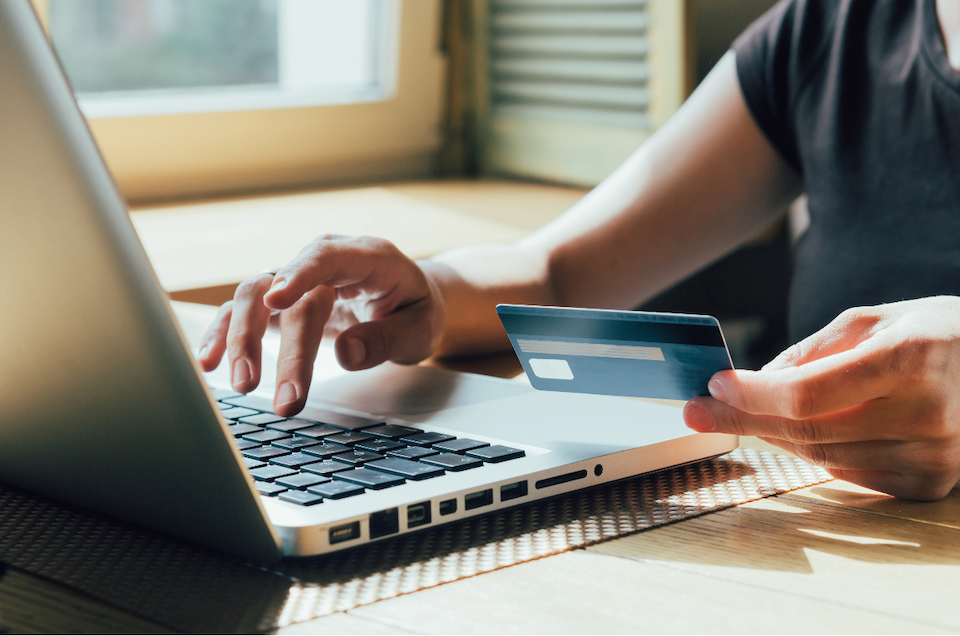 Person making a purchase online, holding a credit card