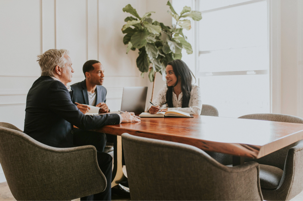 Three colleagues meeting around a conference table