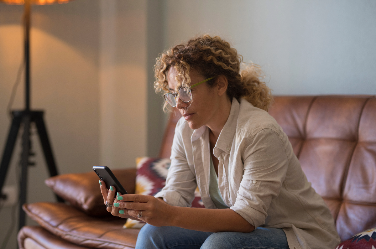 Woman reading on her phone at home