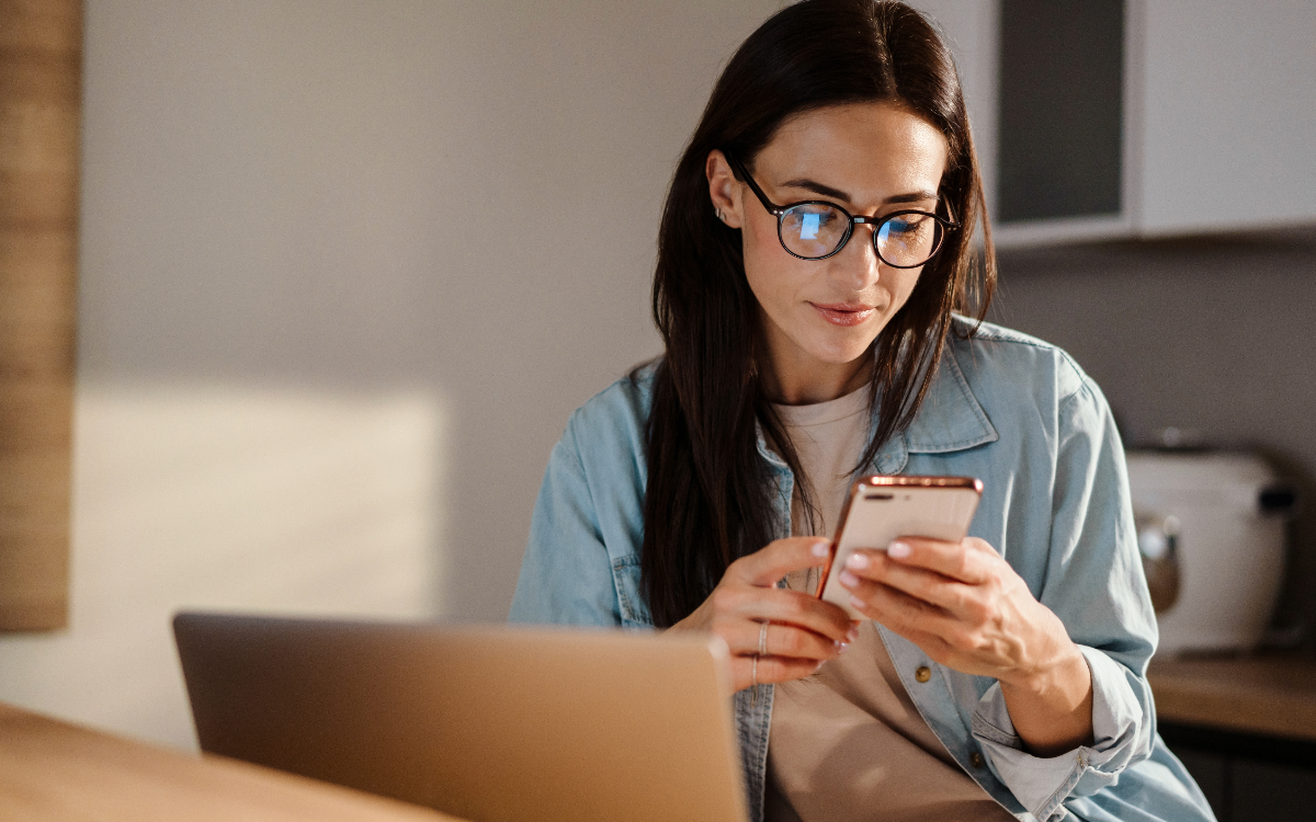 Woman in glasses on a smartphone at home